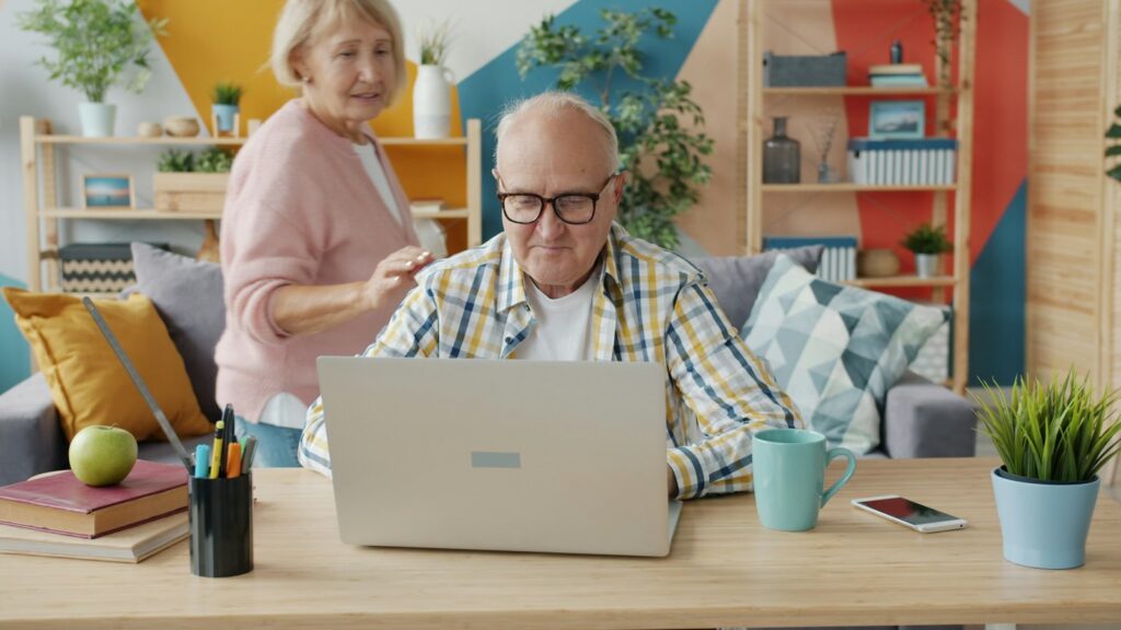 Older adult starting a telehealth visit at home while a family member helps him get connected